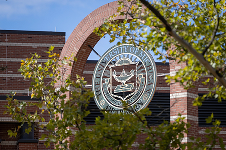 Photo of the UM-Dearborn seal outside of a building.