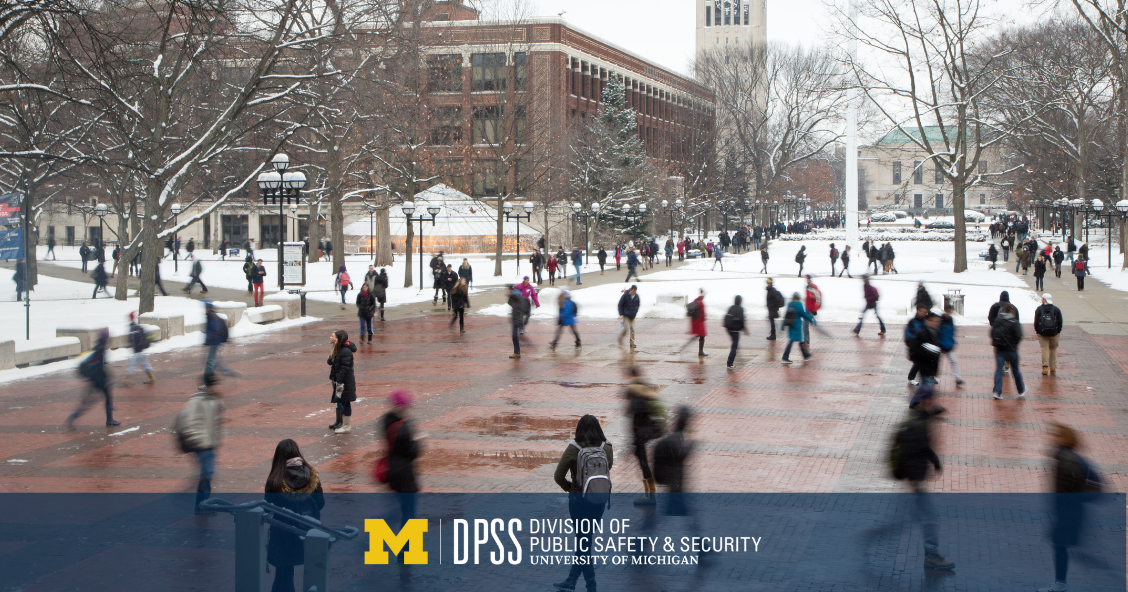 Students walk across the diag in the snow.